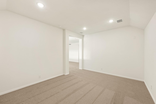 carpeted empty room with lofted ceiling