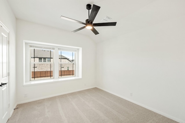 empty room with lofted ceiling, light colored carpet, and ceiling fan