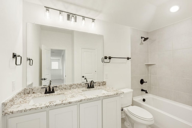 full bathroom with tiled shower / bath, lofted ceiling, vanity, and toilet