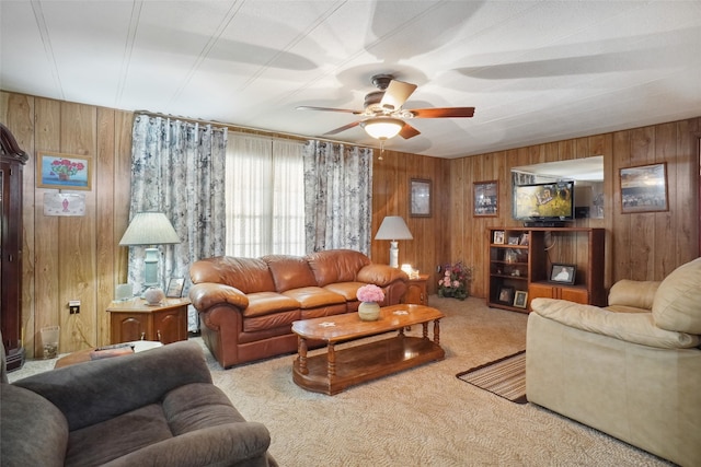 living room with ceiling fan, carpet floors, and wooden walls