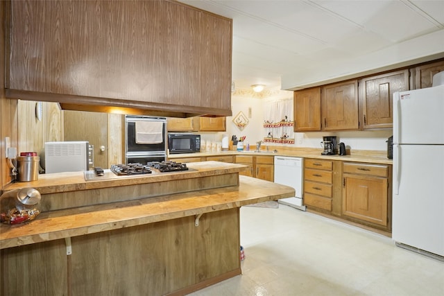 kitchen featuring appliances with stainless steel finishes, light tile patterned floors, a breakfast bar, and butcher block counters