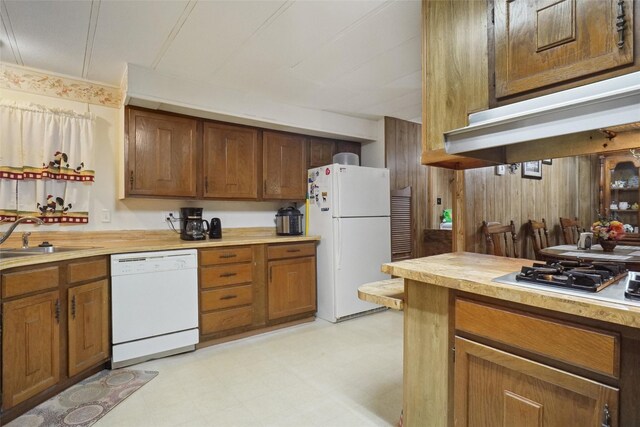 kitchen with light tile patterned floors, white appliances, and sink