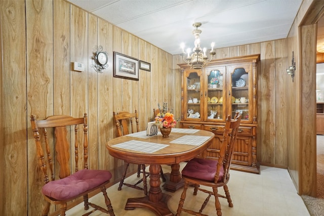 dining area with wooden walls and a chandelier