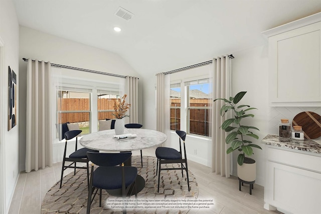 dining room featuring lofted ceiling and a wealth of natural light