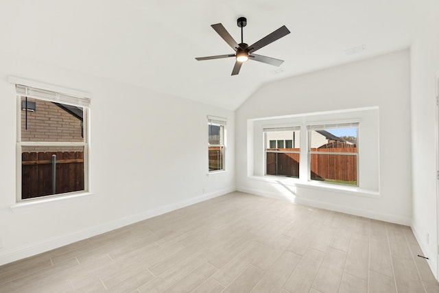 spare room featuring lofted ceiling, ceiling fan, and light wood-type flooring