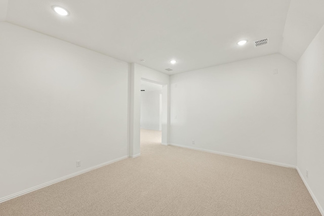 carpeted empty room with lofted ceiling