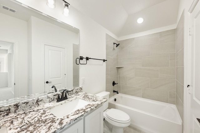 full bathroom with vanity, toilet, tiled shower / bath combo, and vaulted ceiling