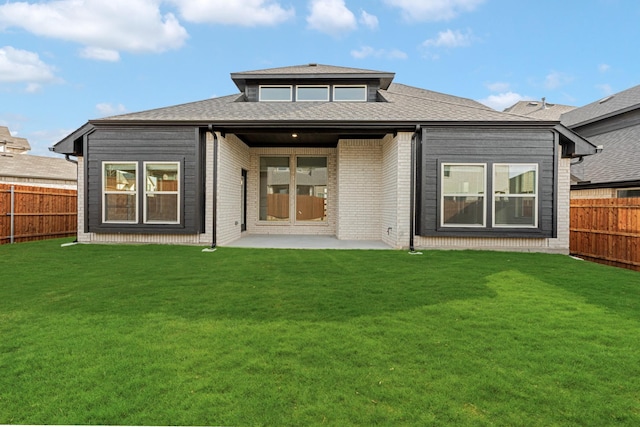 rear view of property with a lawn and a patio