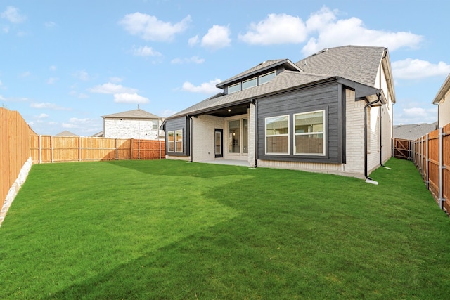 rear view of property with a yard and a patio