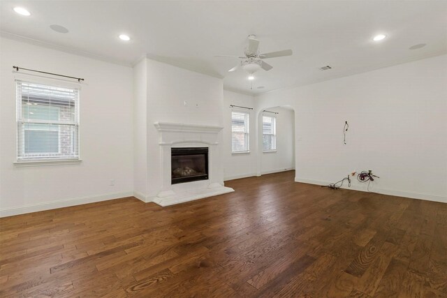 unfurnished living room featuring hardwood / wood-style flooring, crown molding, and ceiling fan