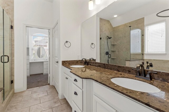 bathroom featuring double vanity, walk in shower, and tile patterned floors