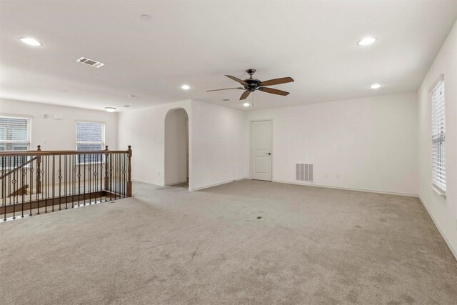 carpeted empty room featuring ceiling fan and plenty of natural light