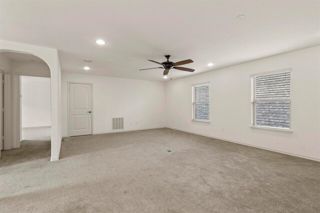 carpeted spare room featuring ceiling fan