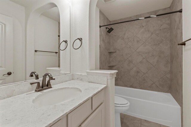 full bathroom with tiled shower / bath combo, vanity, tile patterned flooring, and toilet