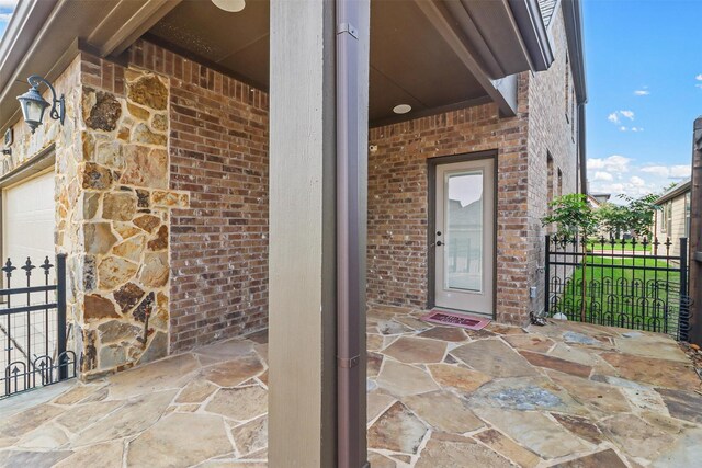 property entrance with a garage and a patio area