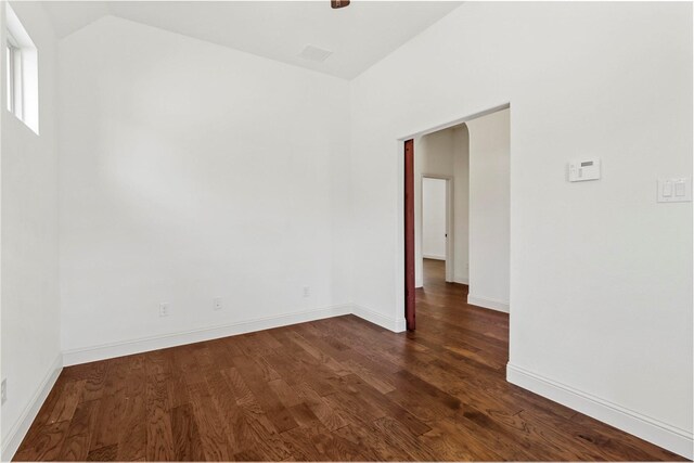 unfurnished room with dark hardwood / wood-style flooring and vaulted ceiling