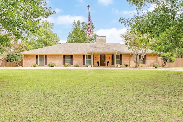 ranch-style home featuring brick siding, fence, roof with shingles, a chimney, and a front yard