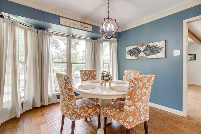 dining space with a notable chandelier, hardwood / wood-style floors, and ornamental molding