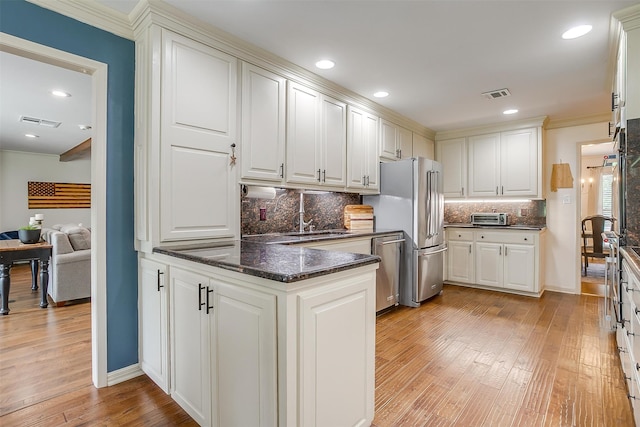 kitchen with decorative backsplash, light hardwood / wood-style floors, white cabinets, and ornamental molding