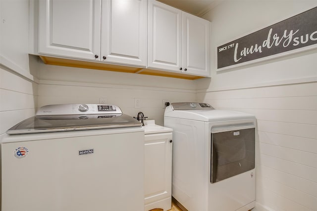 laundry area with washer and clothes dryer and cabinets