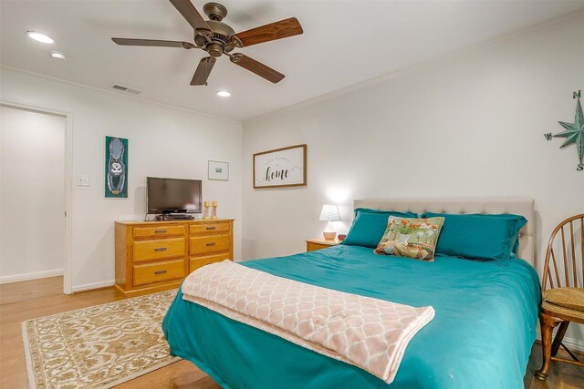 bedroom with ceiling fan, hardwood / wood-style floors, and crown molding