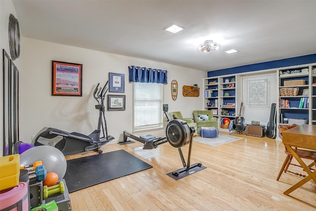 exercise room featuring built in shelves and hardwood / wood-style floors