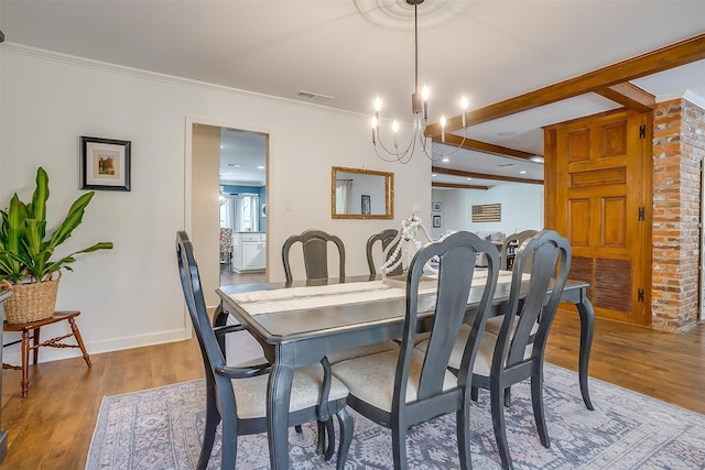 dining space with hardwood / wood-style flooring, beamed ceiling, brick wall, and a chandelier