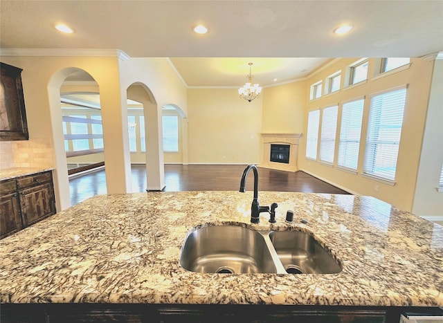 14229 Alis Ln, Frisco, TX 75035 - kitchen featuring an inviting chandelier, light stone countertops, open floor plan, and a sink
