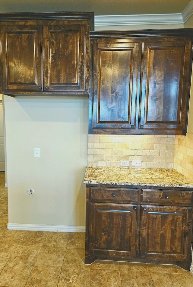 14229 Alis Ln, Frisco, TX 75035 - kitchen featuring dark brown cabinets, baseboards, ornamental molding, light stone counters, and decorative backsplash
