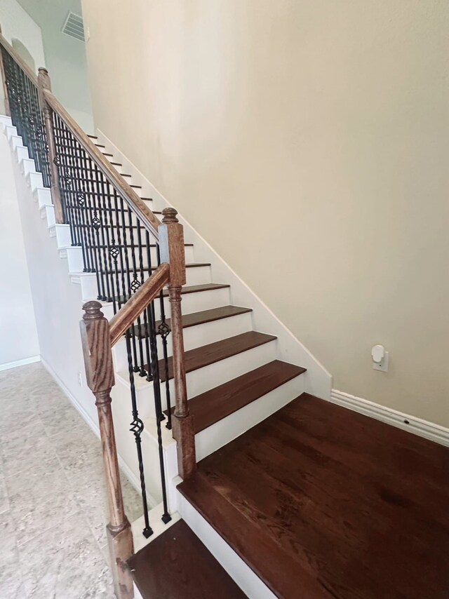 stairway featuring an inviting chandelier, ornamental molding, and a high ceiling