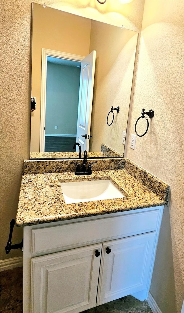 14229 Alis Ln, Frisco, TX 75035 - bathroom with vanity, a textured wall, and baseboards