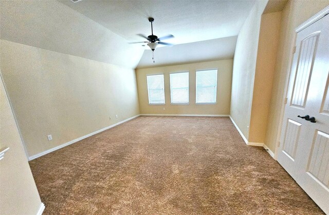 carpeted spare room with ceiling fan and vaulted ceiling