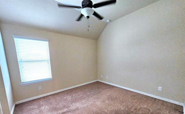 empty room featuring vaulted ceiling, carpet, and ceiling fan