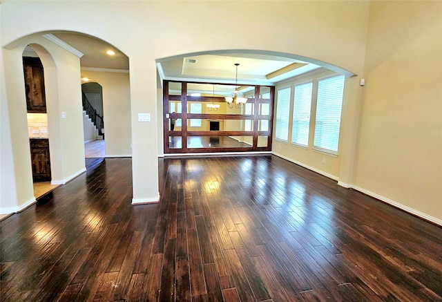 14229 Alis Ln, Frisco, TX 75035 - spare room featuring dark wood-type flooring, ornamental molding, a tray ceiling, baseboards, and a chandelier