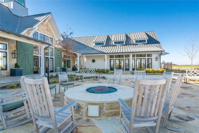 back of property with a patio and a fire pit