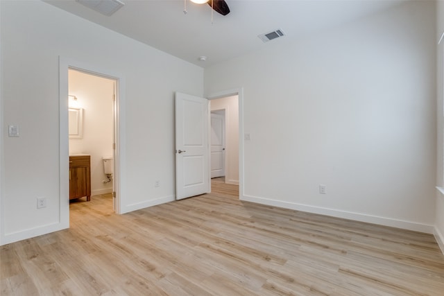 unfurnished bedroom featuring ensuite bathroom, ceiling fan, and light wood-type flooring