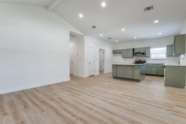 kitchen featuring appliances with stainless steel finishes, green cabinetry, light wood-type flooring, beam ceiling, and high vaulted ceiling