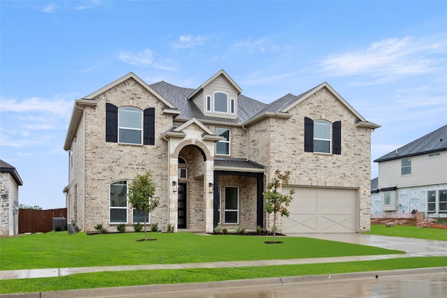 view of front of house with central AC, a front lawn, and a garage