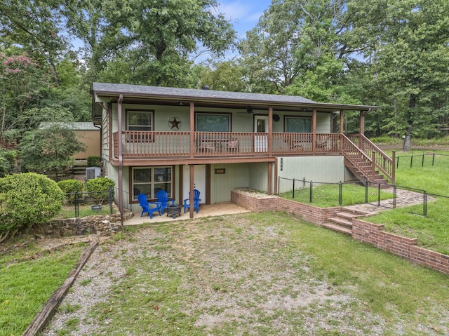 rear view of house featuring central AC unit, a patio area, ceiling fan, and a lawn