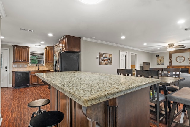 kitchen featuring tasteful backsplash, black appliances, crown molding, dark hardwood / wood-style floors, and ceiling fan