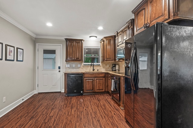 kitchen featuring dark wood-type flooring, crown molding, black appliances, and backsplash