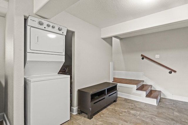 laundry area with stacked washing maching and dryer and a textured ceiling