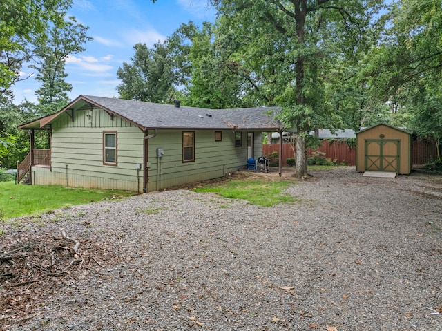 rear view of property with a storage shed