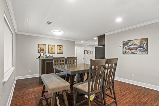 dining space featuring ornamental molding and dark hardwood / wood-style flooring