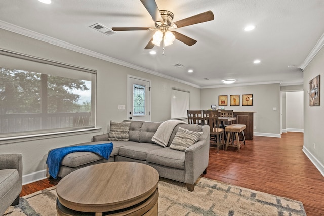 living room with ceiling fan, wood-type flooring, and ornamental molding