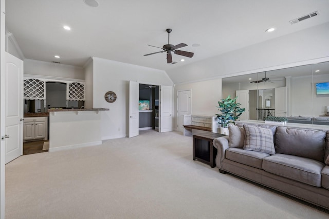 carpeted living room featuring crown molding, bar, and ceiling fan