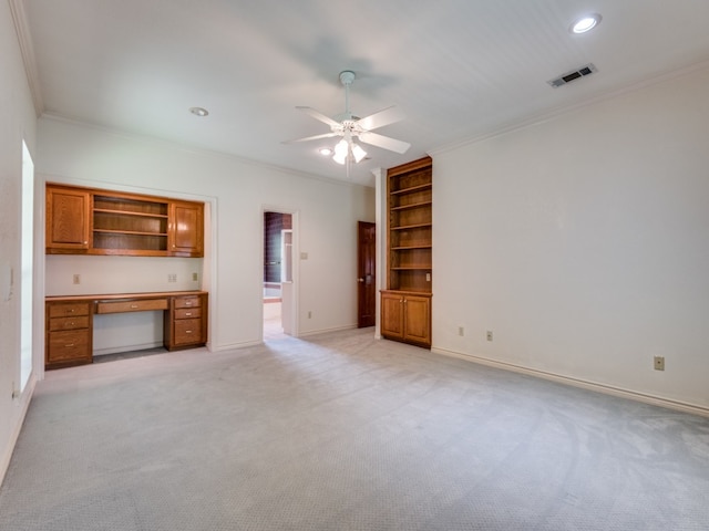 unfurnished living room featuring visible vents, ornamental molding, baseboards, light colored carpet, and built in study area