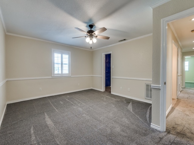 unfurnished room featuring carpet flooring, a healthy amount of sunlight, crown molding, and baseboards