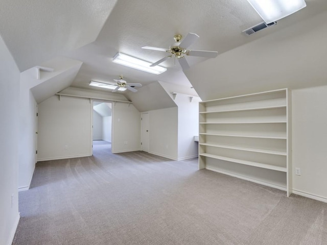 bonus room with visible vents, ceiling fan, lofted ceiling, carpet flooring, and a textured ceiling