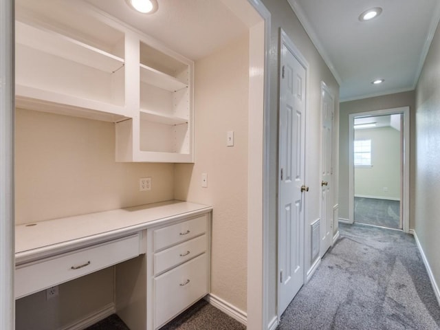 hallway with crown molding, recessed lighting, baseboards, and dark colored carpet